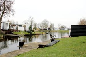 Blick auf einen Fluss mit einem Dock und Häusern in der Unterkunft Vakantie Chalet T30 - Makkum in Makkum