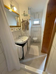 a white bathroom with a sink and a toilet at Ferienhaus Langer in Bad Endorf