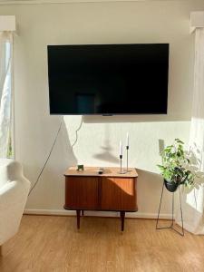 a living room with a flat screen tv on a wall at Romslig kystperle med sjel i Skulsfjord Tromsø in Tromsø