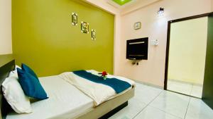 Un dormitorio con una cama con una pared verde. en Hotel Adarsh Palace, en Maheshwar