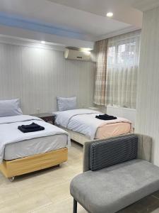 een hotelkamer met twee bedden en een stoel bij KAMER Apart Hotel in Istanbul