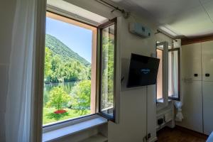 Habitación con ventana grande con vistas al lago en Vista Lago-Appartamento Giardino dell'Eden, en Ghirla
