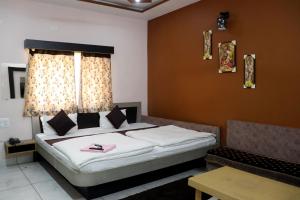 Un dormitorio con una cama grande y una ventana. en Hotel Adarsh Palace, en Maheshwar