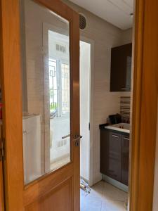 a kitchen with a door open to a kitchen with a sink at Maison haut, standing in Ariana