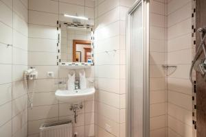een badkamer met een wastafel en een spiegel bij Ferienhaus Hubertus - PRECHTLHOF in Flachau