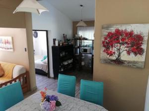 a living room with a table and a tree painting on the wall at Casa del Cerro San Javier in Yerba Buena