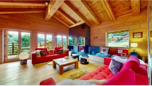 a living room with a red couch and a table at Chalet Les Moulins 5 chambres cheminée piscine sauna parking privé in Verbier