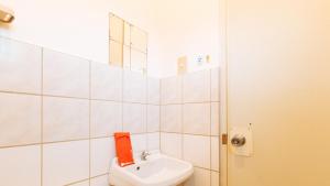 a bathroom with a white toilet and a sink at MBU Suites Bed n Breakfast RedPartner in Guiguilonen
