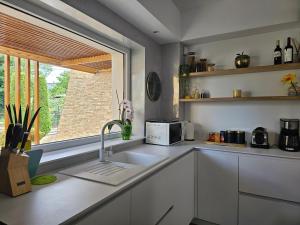 a white kitchen with a sink and a window at Casa Maia in Eforie Sud