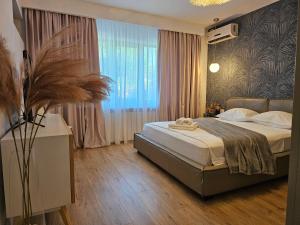 a bedroom with a bed and a large window at Casa Maia in Eforie Sud