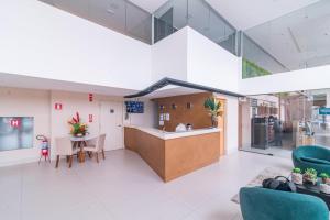 a lobby with a counter and a table and chairs at Gold flat Manaíra 602 in João Pessoa