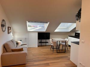 sala de estar con 2 tragaluces y mesa con sillas en Casa del Moro, en Brescia