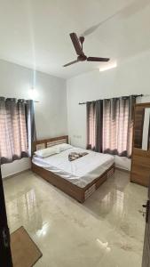 a bedroom with a bed and a ceiling fan at VENUE DAYS homestays in Meenangadi