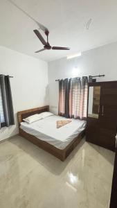 a bedroom with a bed and a ceiling fan at VENUE DAYS homestays in Meenangadi