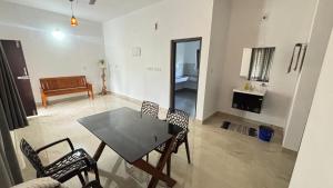 a dining room with a table and chairs and a piano at VENUE DAYS homestays in Meenangadi +12 photos
