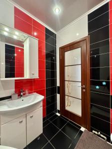 bagno con lavandino e parete rossa e nera di ApartPoltava Неповторні апартаменти в ЦЕНТРІ Полтави КОРПУСНИЙ ПАРК a Poltava Altre 7 foto