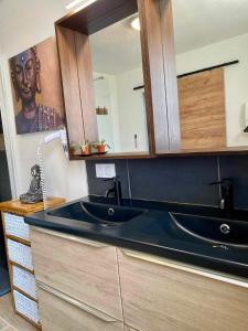 a kitchen with a black sink and a mirror at Gites L etape conviviale in Guitté +41 photos