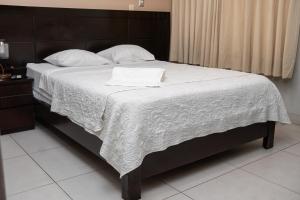 Ένα ή περισσότερα κρεβάτια σε δωμάτιο στο Cacique Hotel