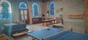 a living room with a ping pong table and stained glass windows at Chapelle Notre Dame du Rail in Jarny