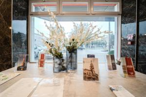 a table with a vase of flowers and cards on it at Hotel Donatello in Modena