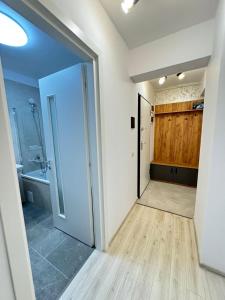 an open door to a bathroom with a sink at Luxury Glam Apartments Coresi Mall Area in Braşov