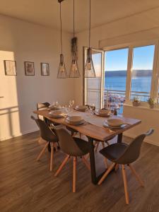 a dining room with a table and chairs and the ocean at Apartman Buba in Jesenice