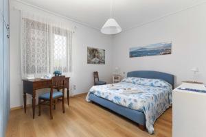 a bedroom with a bed and a desk and a table at AMORE RENTALS - Villa Grazia in Castellammare di Stabia +41 photos