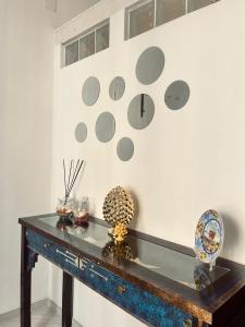 une table dans une pièce avec une horloge sur le mur dans l'établissement La Casetta Isonzo, à Syracuse