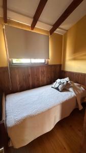 a bedroom with a white bed with a window at Casa AYKA in Panguipulli