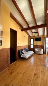 a living room with a couch in a room with wooden floors at Casa AYKA in Panguipulli