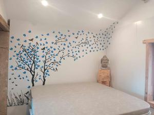 a bedroom with a bed with blue birds on the wall at Ferme des molieres avec espace détente in Mortagne