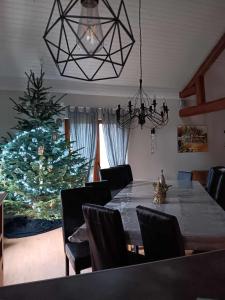 a dining room with a table and a christmas tree at Ferme des molieres avec espace détente in Mortagne