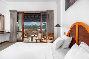 ベントータにあるHotel Nilwalaのベッドとバルコニーのある寝室