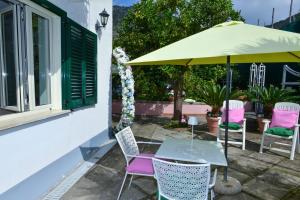 a table and chairs under an umbrella on a patio at I giardini di Daphne in Meta