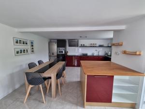 a kitchen with a wooden table and chairs at l'Escapade Charentaise in Mons