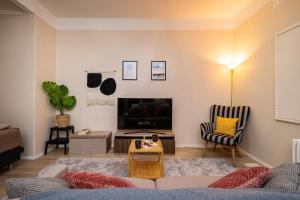 a living room with a couch and a tv at Modern & Bright Central Helsinki in Helsinki