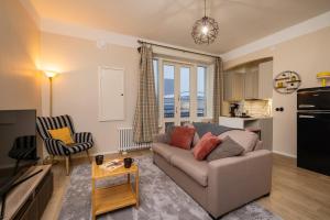 a living room with a couch and a kitchen at Modern & Bright Central Helsinki in Helsinki