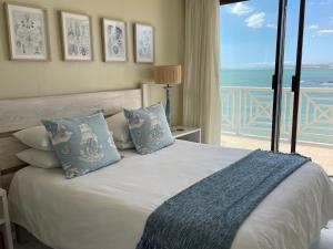 a bedroom with a bed with a view of the ocean at By Die See in Gordonʼs Bay