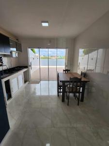 a kitchen and dining room with a table and chairs at Apartamento-3 pé na areia, churrasqueira, acesso a lagoa, vista para rio, Torres e serra gaúcha in Passo de Torres