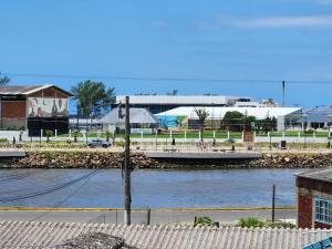 a view of a river with a pier and buildings at Apartamento-3 pé na areia, churrasqueira, acesso a lagoa, vista para rio, Torres e serra gaúcha in Passo de Torres
