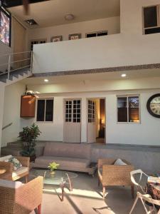 a living room with a couch and chairs and a clock at Casa Luz very nice in Nuevo Nayarit in Nuevo Vallarta 
