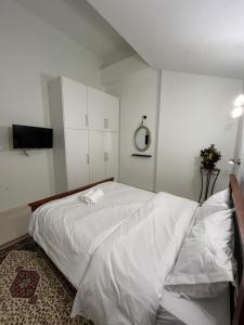 a bedroom with a large bed with white sheets at Jimilio 1 in Spata