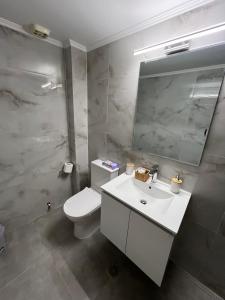 Un baño con inodoro, lavabo y espejo. en Jimilio 1, en Spáta 8 fotos más