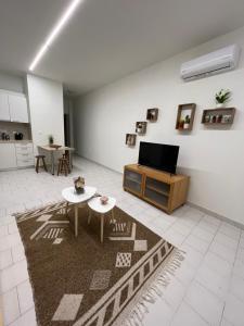 Una sala de estar con un televisor y una mesa. en Jimilio 1, en Spáta