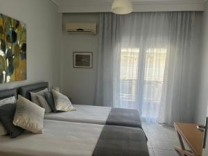 a bedroom with a large bed with a window at Central Park Kallikrátia in Nea Kallikrateia