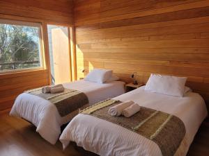 Postel nebo postele na pokoji v ubytování Huillín Lodge