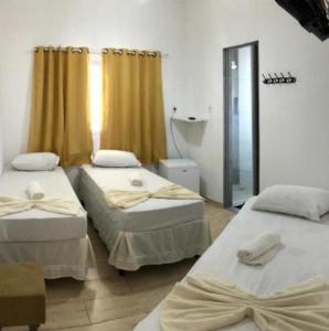 a room with two beds and a shower in it at Pousada MC in Aparecida