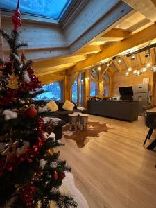 a living room with a christmas tree in the middle at La Rose des neiges à Châtel in Châtel