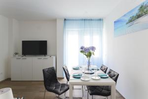 una sala da pranzo bianca con tavolo e sedie bianchi di Well Done - 50mt Isola Pedonale Centro - 10 Min Mare a San Benedetto del Tronto