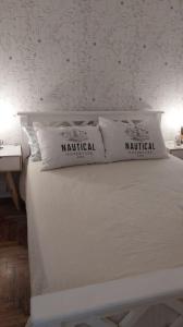een wit bed met twee kussens erop bij Travel ART! in Mar del Plata
